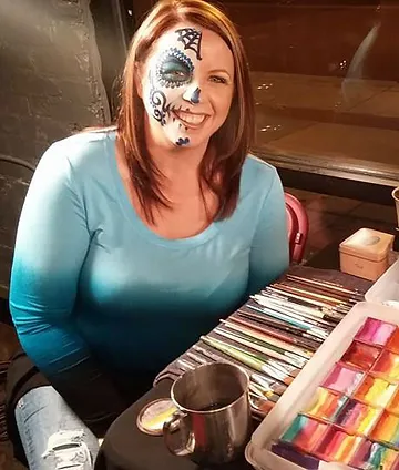 portrait of the artist with half painted face in colorful skull makeup